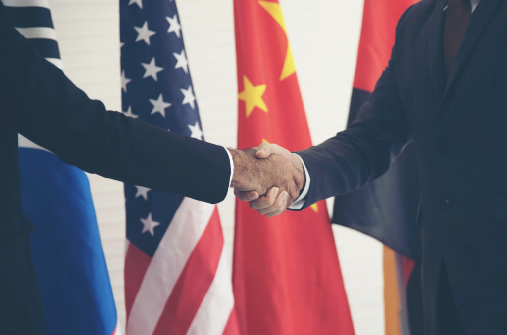 Diplomats shaking hands in front of national flags, Tech Diplomacy Newsletter October 2026